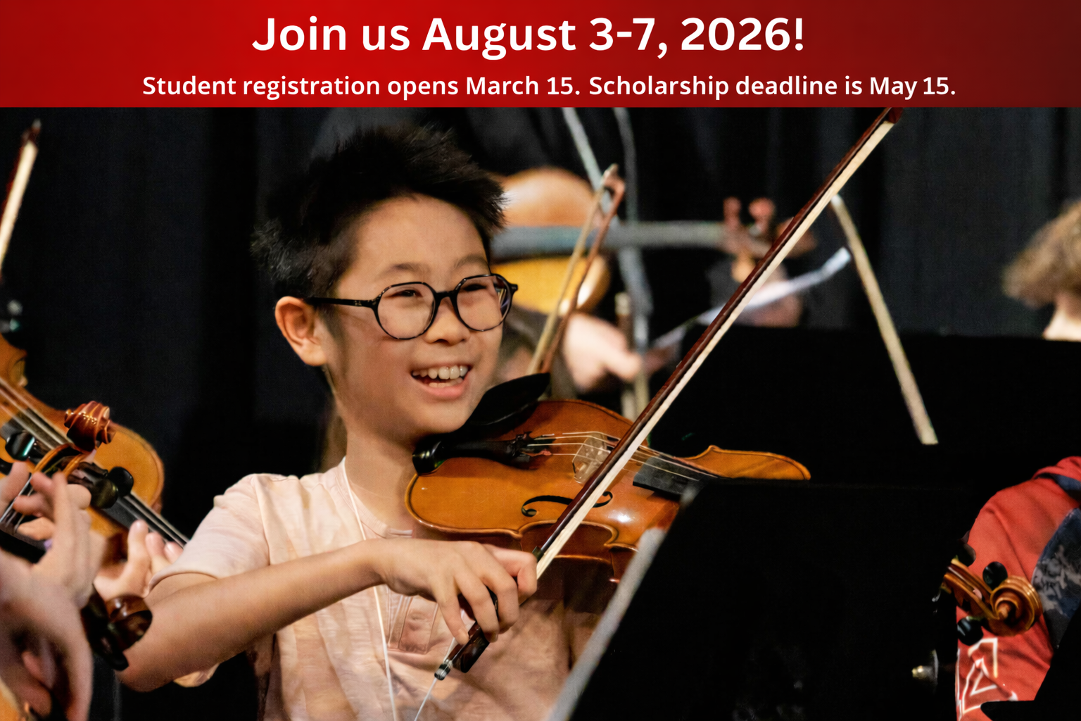 Smiling boy plays violin in orchestra